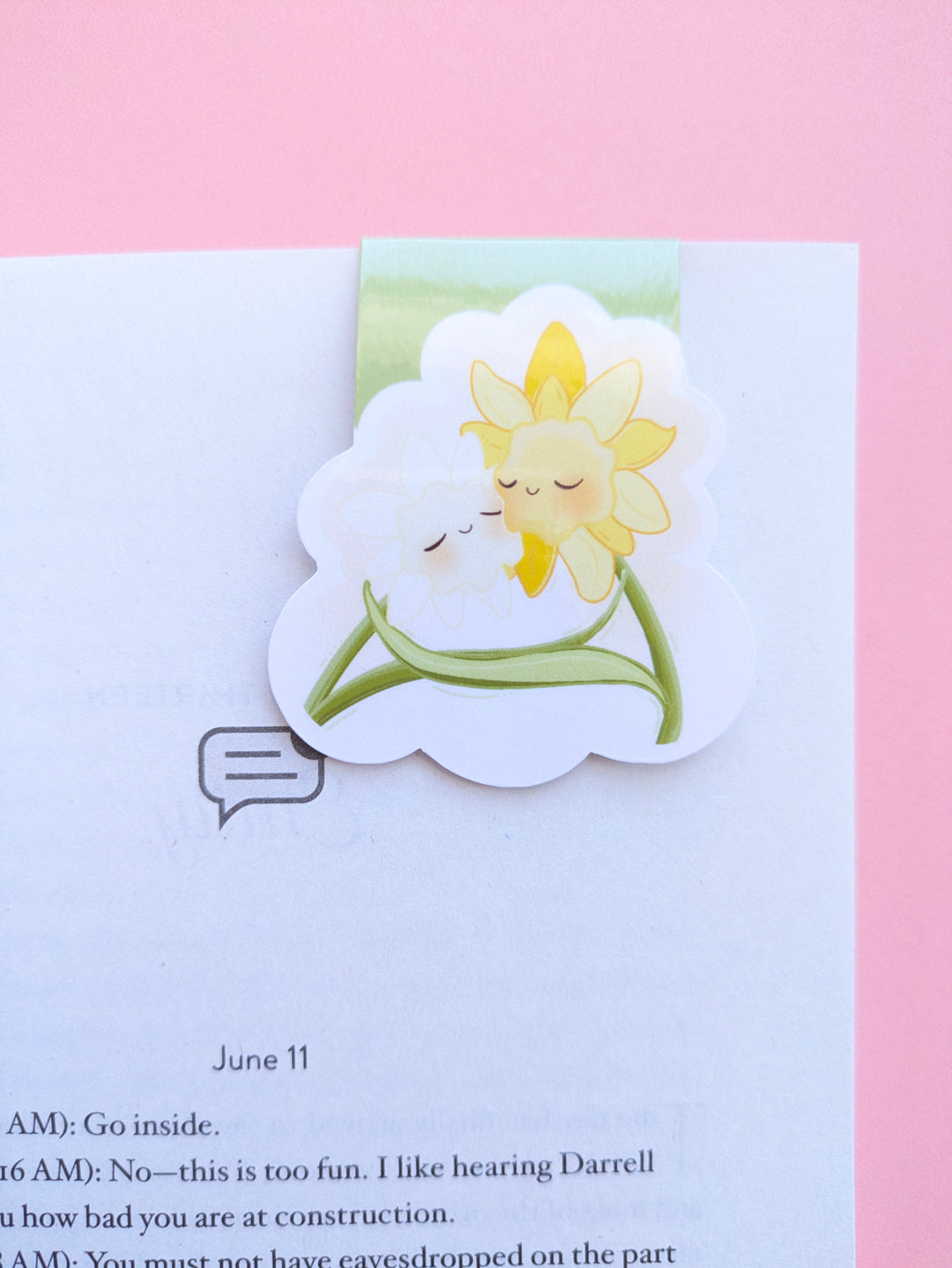 A high aesthetic close up reading ritual featuring the Daffodil Hug Szn 'Meadow Mist' magnetic bookmark clipped to Sarah Adams’ 'Beg, Borrow, or Steal.' This bright, mist meadow green kawaii character bookmark is clipped securely to a crisp white page, reflecting light off its high-gloss finish against a rose-pink background. Perfect for curated book annotating and visual life building in a monochrome green palette.