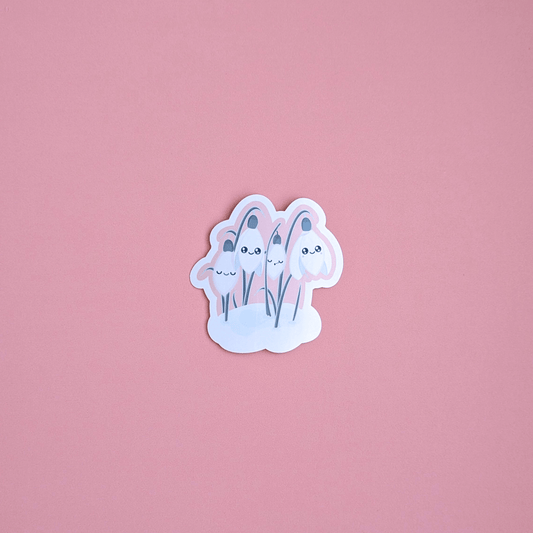 Ateu Studio Sleepy Snowdrop sticker in the Icy Venusian Pink colorway, featuring Snowdrop White characters with sage-silver leaves and a cozy soft-glow effect. This high-detail aerial close-up on a rose-pink background highlights the pastel palette and double-shine eyes, perfect for pink-themed Kindle decorating.