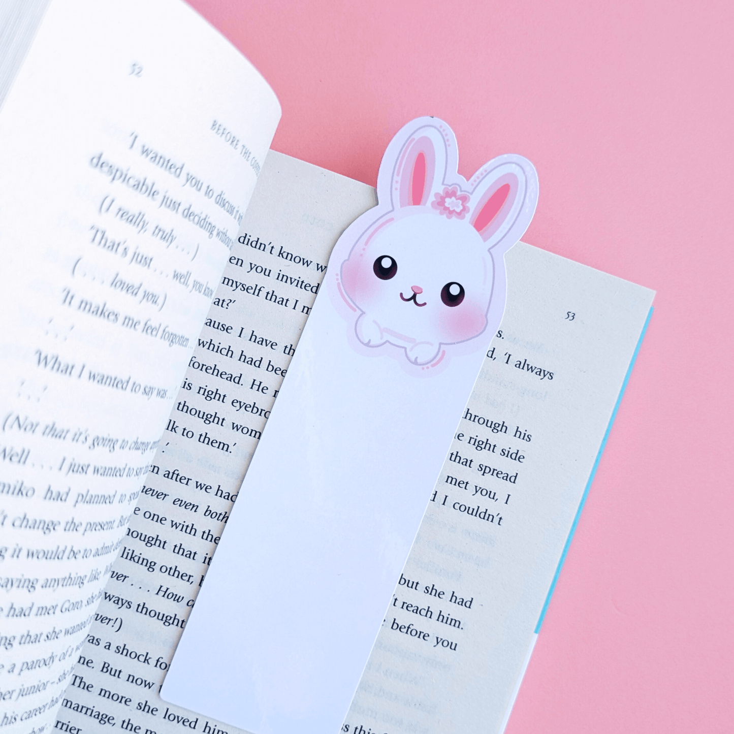 Ateu Studio’s Marshmallow Blush Bunny character bookmark with a Snowball White base, resting on an open copy of Before the Coffee Gets Cold. The long eared bunny design and soft pink background highlight a cozy, color-obsessed reading aesthetic perfect for book journaling.