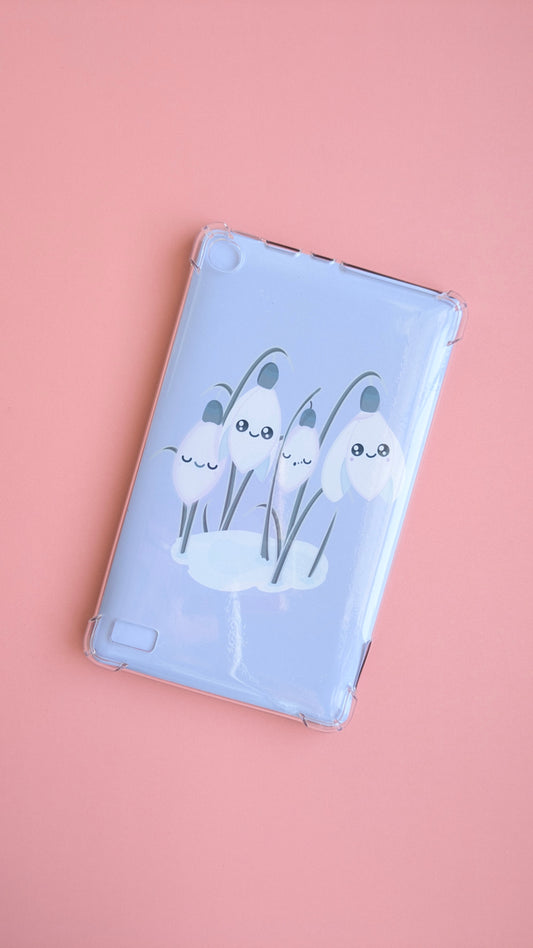 A centered Kindle with the 'Sleepy Snowdrops Dawn Lavender Blue Kindle Paperwhite Insert' at an angle. This naturally lit photo focuses on the lovely gloss light sheen across the lavender-blue morning sky design, emphasizing the premium material quality and clean winter reset.