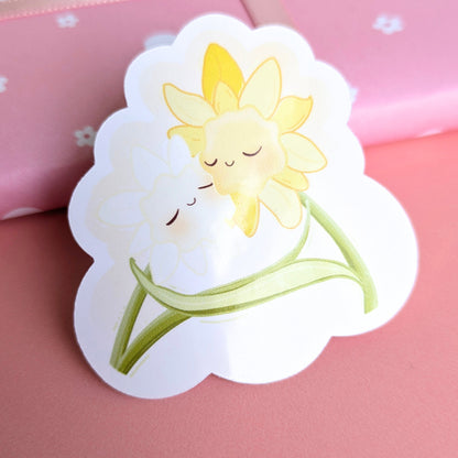 Ateu Studio Daffodil Hug SZN gloss vinyl sticker showing a reflective sheen in natural afternoon sunlight. This close-up highlights the water-resistant finish and vibrant spring colors, ideal for personalizing water bottles and tech.