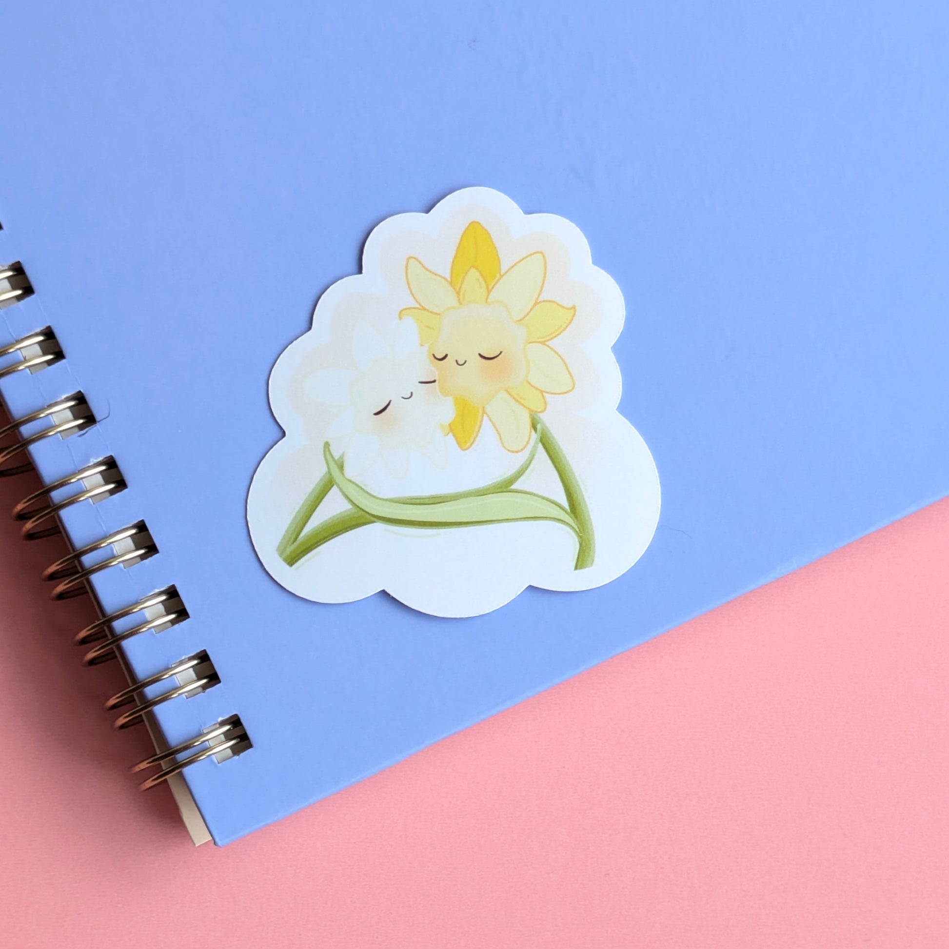 Daffodil Hug SZN gloss sticker staged on a pale lavender notepad. This straight-on shot emphasizes the aesthetic pairing of lavender and yellow, essential for visual life-building and spring-themed tech-scaping.