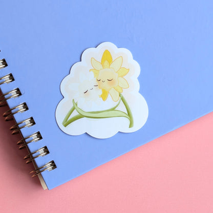Daffodil Hug SZN gloss sticker staged on a pale lavender notepad. This straight-on shot emphasizes the aesthetic pairing of lavender and yellow, essential for visual life-building and spring-themed tech-scaping.