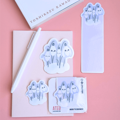 An airy, minimalist reading nook scene featuring Ateu Studio Sleepy Snowdrop 'Dawn' stationery styled with Toshikazu Kawaguchi’s 'Before the Coffee Gets Cold.' The lavender-blue and Snowdrop White stickers, gloss bookmark, and magnetic bookmark are arranged on a pink pocket notebook. This bright, breathable rose-pink composition captures a cozy moment of aesthetic joy, ideal for book annotating and Kindle decorating.