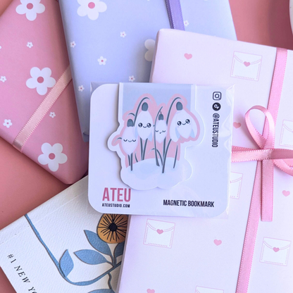 A close-up view of the Ateu Studio Kawaii Sleepy Snowdrop 'Icy Venusian' Pink magnetic bookmark on its branded backing card. The retail packaging shows the&nbsp;Kawaii character art clearly, with a soft light reflection. This shot highlights the premium presentation designed for aesthetic planning and book-safe decorating -&nbsp;an essential, book safe gift add-on for curated literary bundles.
