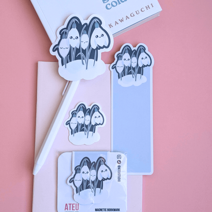 An airy reading nook scene featuring an Ateu Studio Sleepy Snowdrop atmospheric teal stationery set styled with Toshikazu Kawaguchi’s 'Before the Coffee Gets Cold.' The Snowdrop White characters with a cozy soft-glow effect are arranged on a pink pocket notebook, capturing a bright, breathable moment of aesthetic joy for book annotating. 