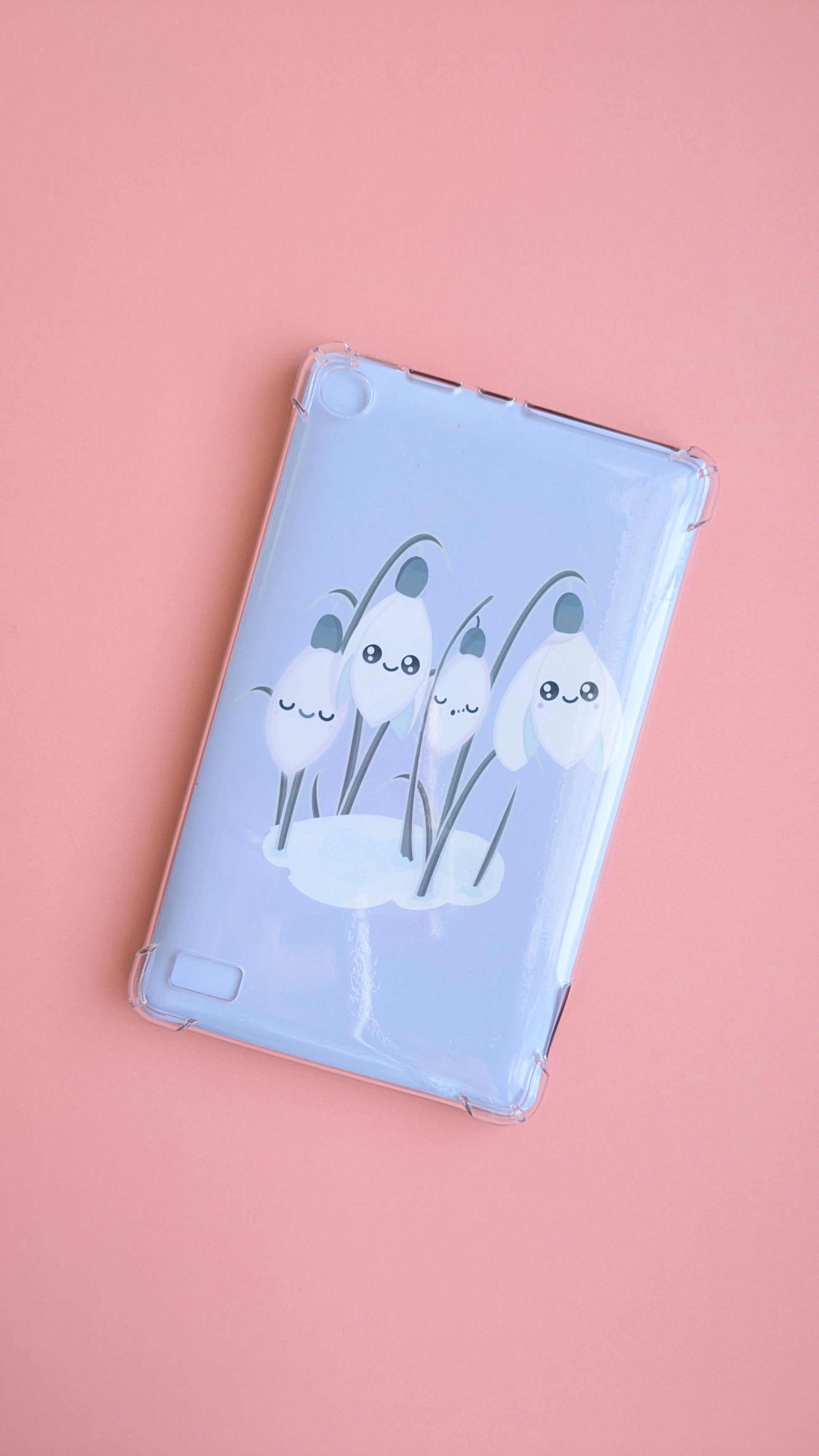 A centered Kindle with the 'Sleepy Snowdrops Dawn Lavender Blue Kindle Paperwhite Insert' at an angle. This naturally lit photo focuses on the lovely gloss light sheen across the lavender-blue morning sky design, emphasizing the premium material quality and clean winter reset.